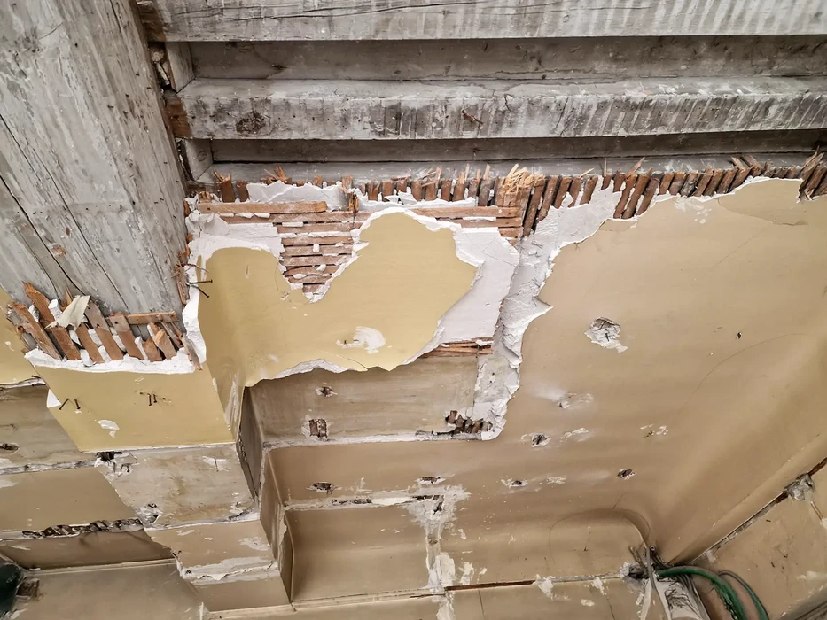 Intérieur d'un bâtiment en cours de rénovation avec plafond endommagé