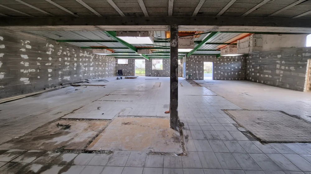 Chantier de construction intérieur en cours, espace ouvert avec poutre porteuse centrale