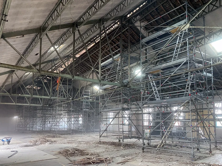 Intérieur d'un bâtiment en rénovation avec échafaudages métalliques modulaires multi-niveaux