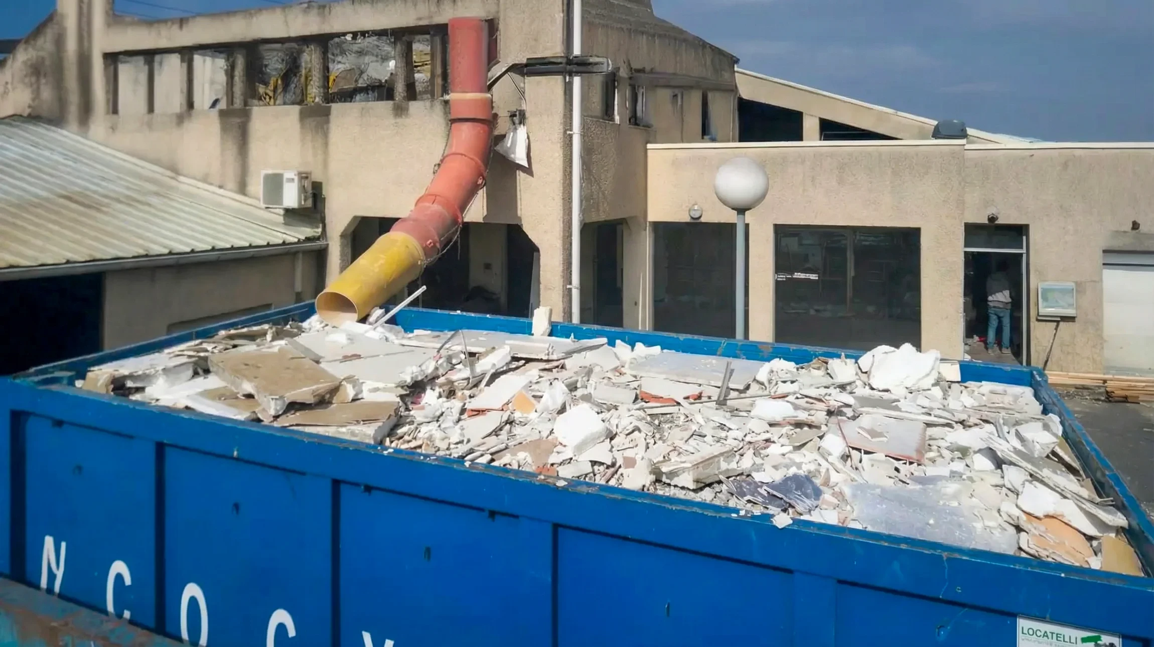 Chantier de construction extérieur avec ouvrier en équipement de sécurité observant les travaux