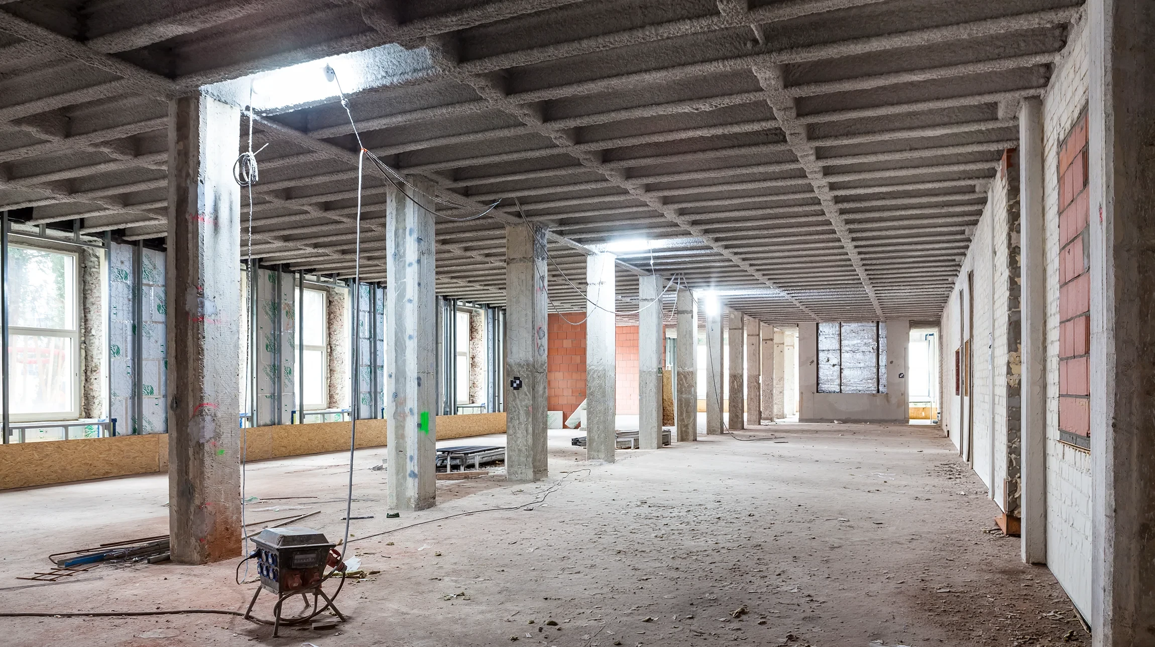 Deux ouvriers du bâtiment portant casques de sécurité blancs dans un chantier intérieur