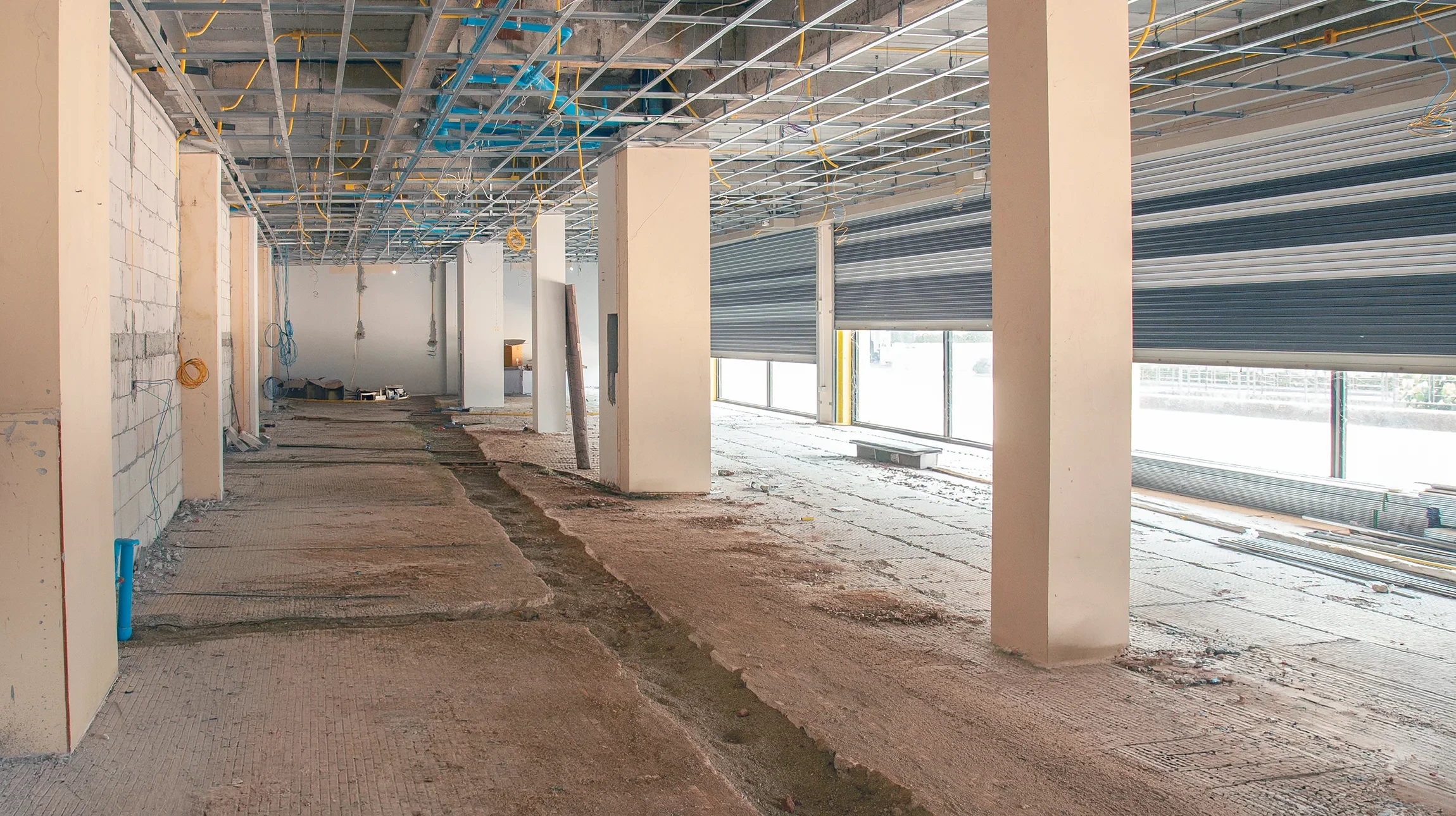 Ouvrier en démolition intérieure utilisant un marteau-piqueur pneumatique sur mur en béton et brique