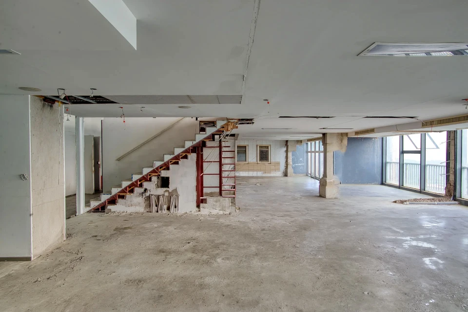 Deux ouvriers du bâtiment portant casques de sécurité blancs dans un chantier intérieur